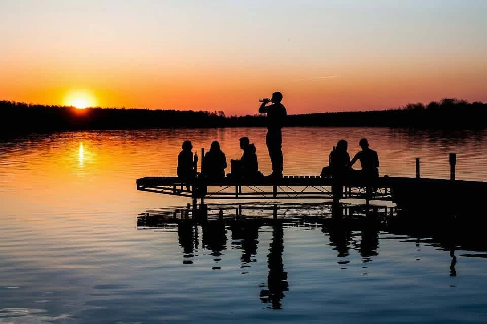 Friends gathered on a dock at sunset over Lake Tawakoni
